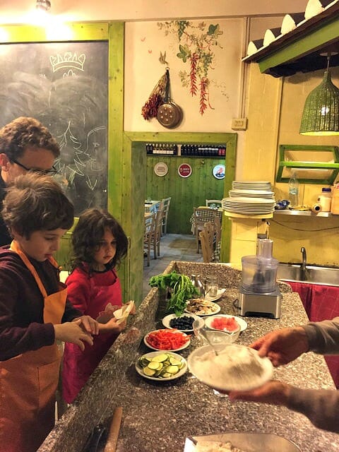 Pizza making class for kids: our children cooking pizza in a traditional Rome pizzeria