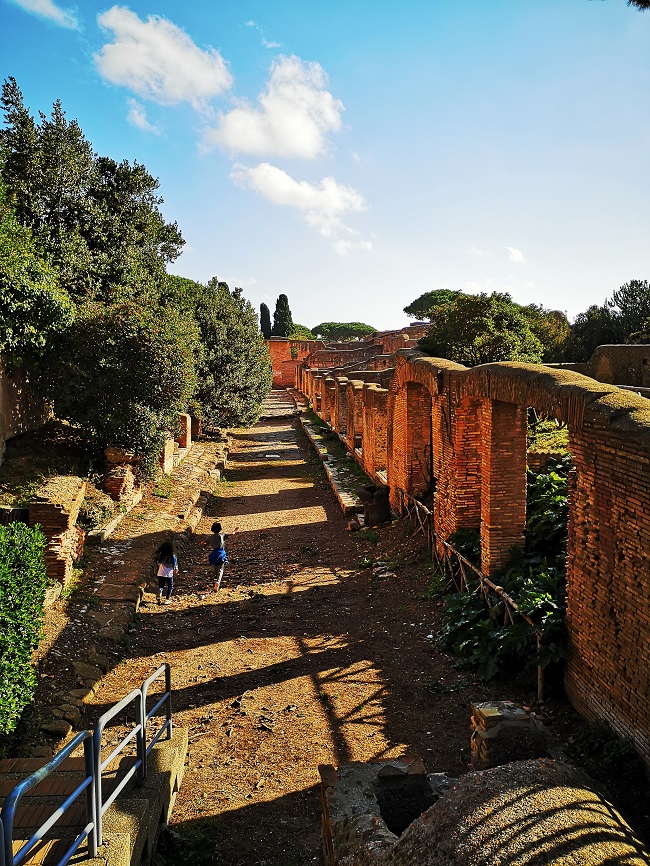 Ostia antica road with brick walls and kids running