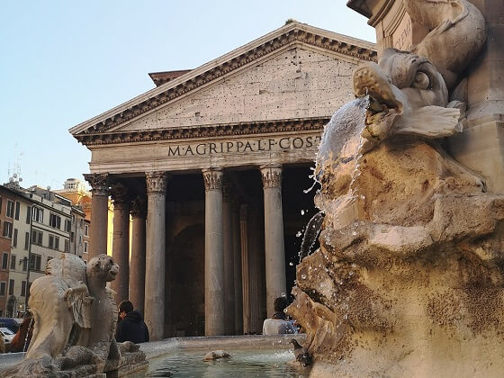 Fountain in front of Rome Pantheon with Pantheon colonnade in the background