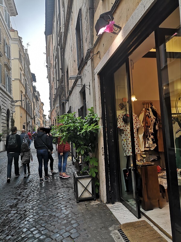 Rome shopping street with cobbles and people wearing sneaker style shoes