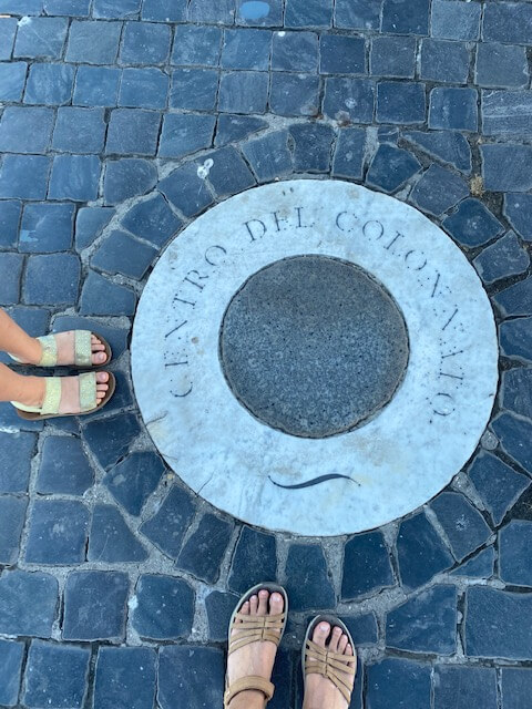 feet of woman and small girl wearing walking sandals on cobbled street - best shoes for Rome travel 