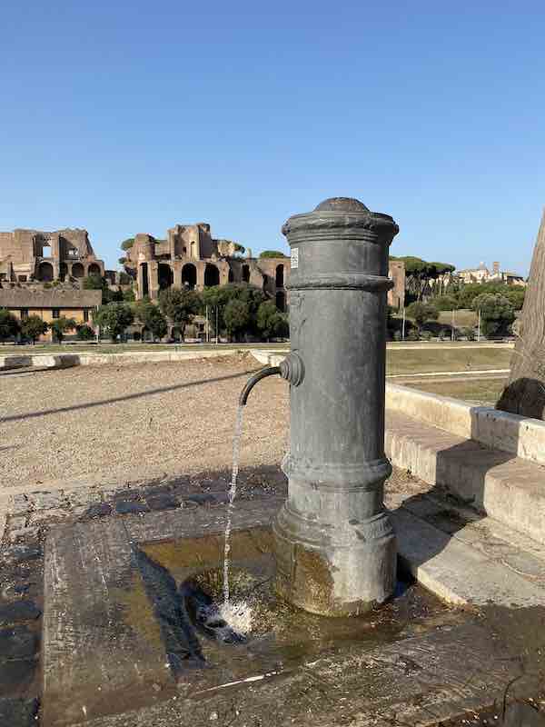 Rome drinking fountain (nasone) with the Palatine Hill in the background