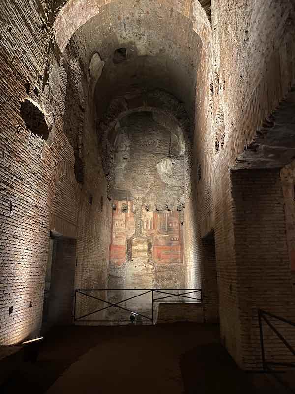 Corridor in Domus Aurea with red and white frescoes at the end