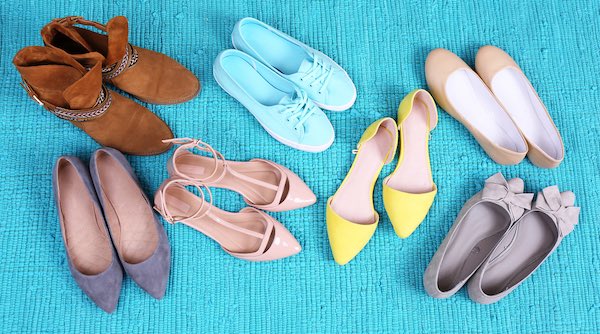 selection of different style of women shoes on light blue rug 