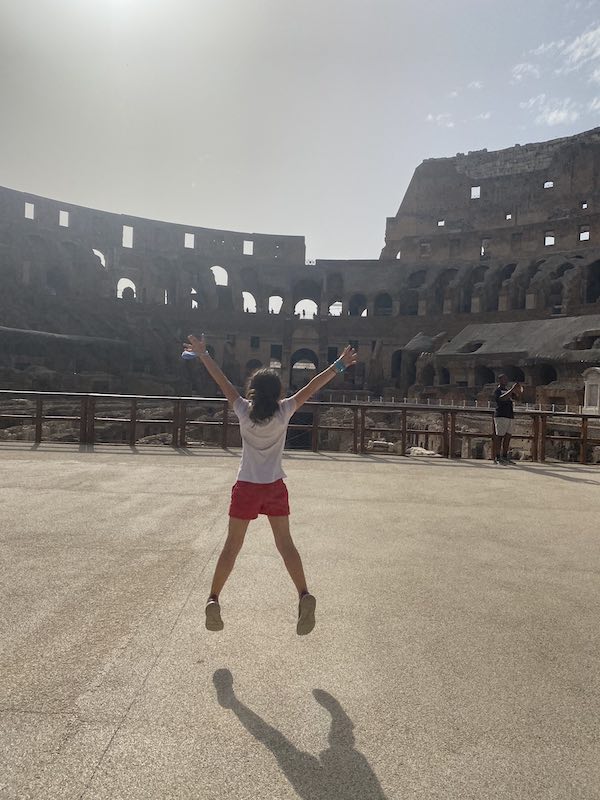 Child jumping on the arena floor of the Colosseum in Rome