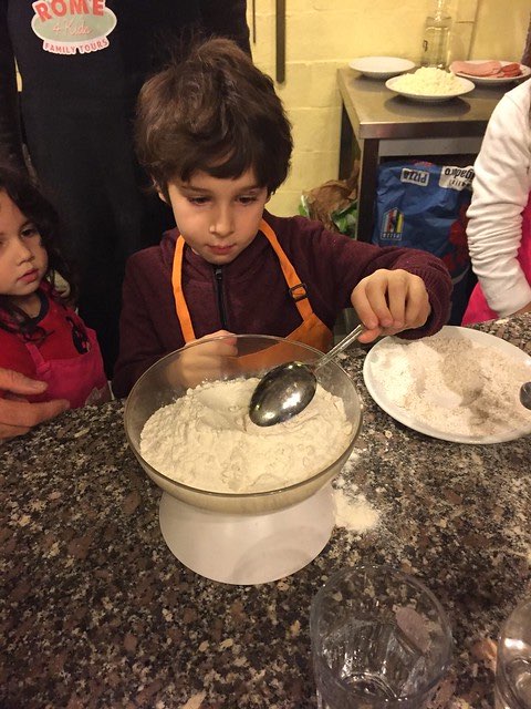 My son measuring ingredients while taking a pizza making class in Rome