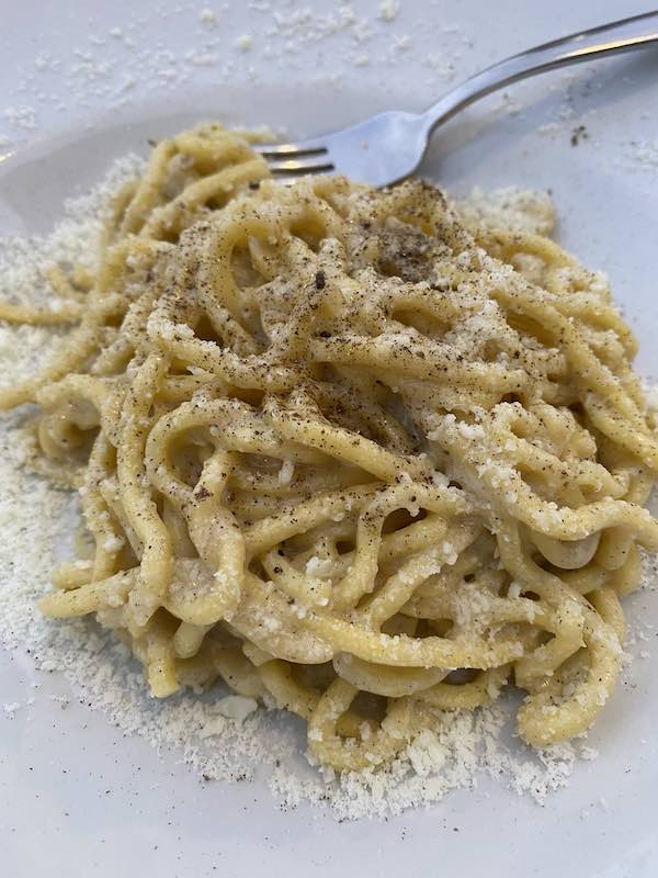 cacio e pepe pasta on white plate in Rome
