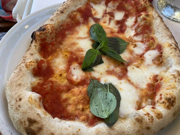 High crust pizza with tomato sauce, mozzarella and basil leaves