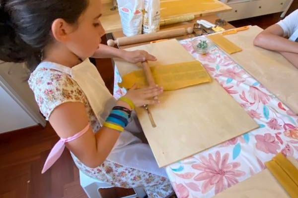 My 10 year old daughter making pasta in a kid-friendly pasta making class in Rome Italy 