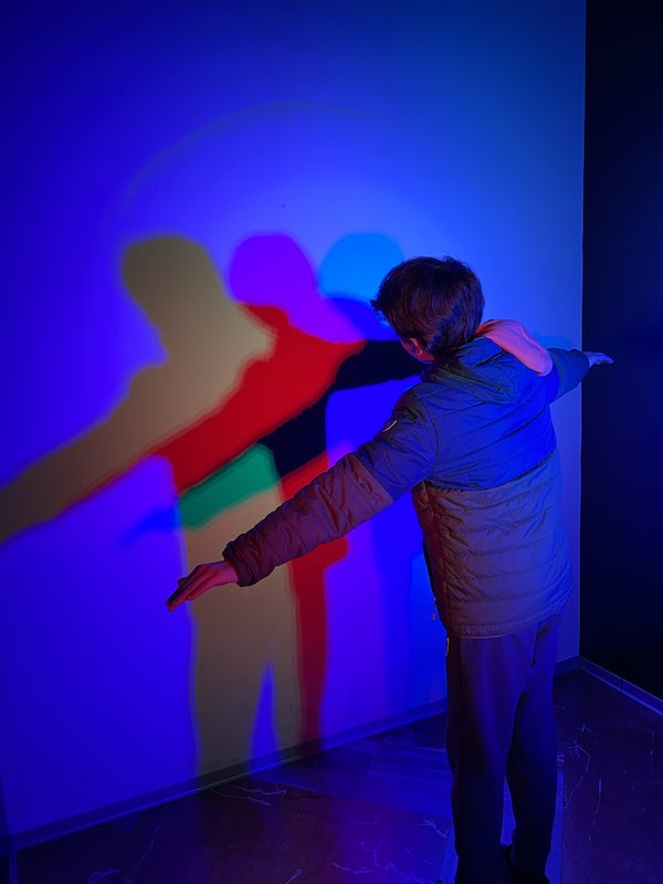 My son playing with colourful lights in the Museum of Illusions in Rome 
